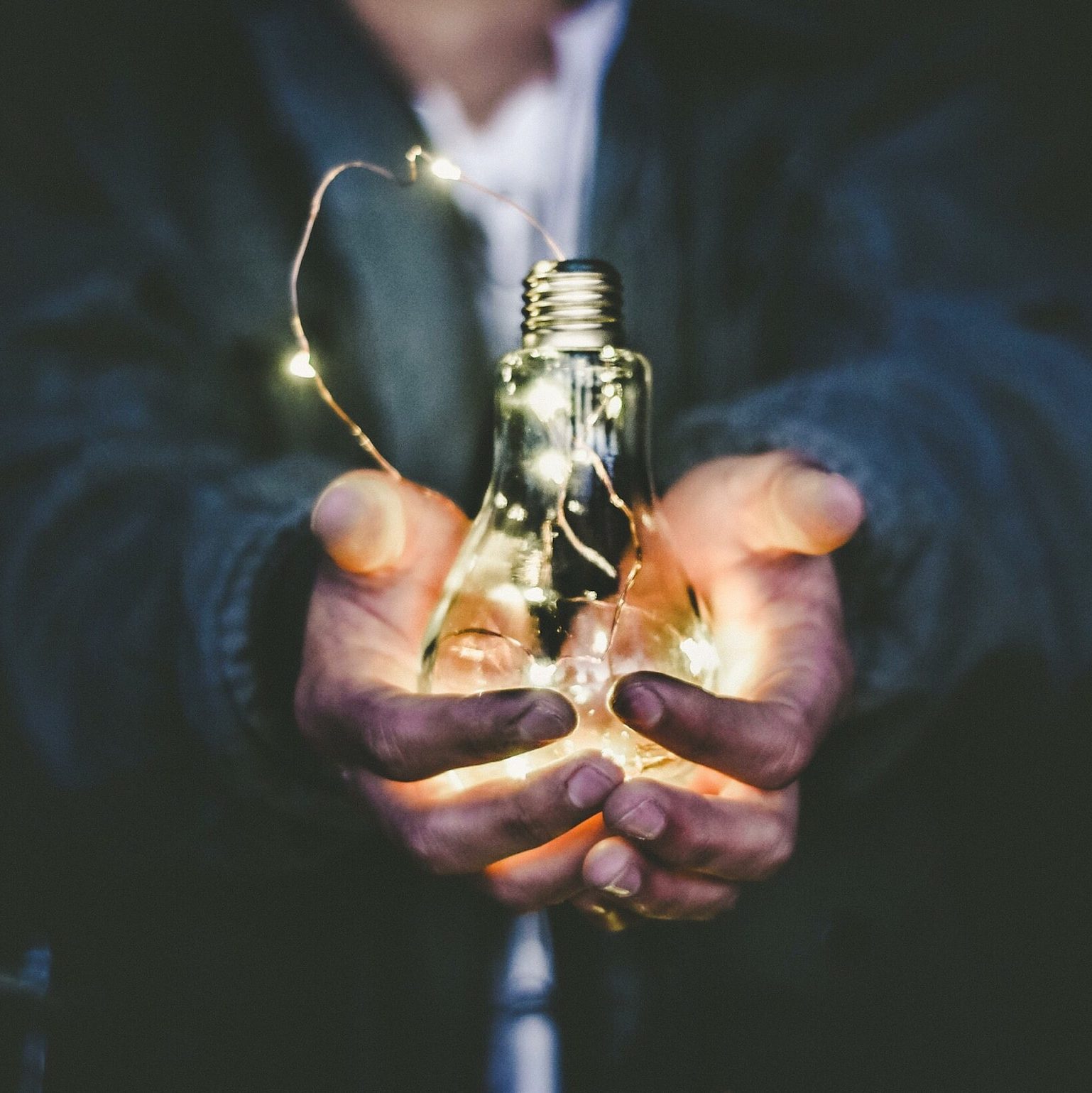 man holding incandescent bulb